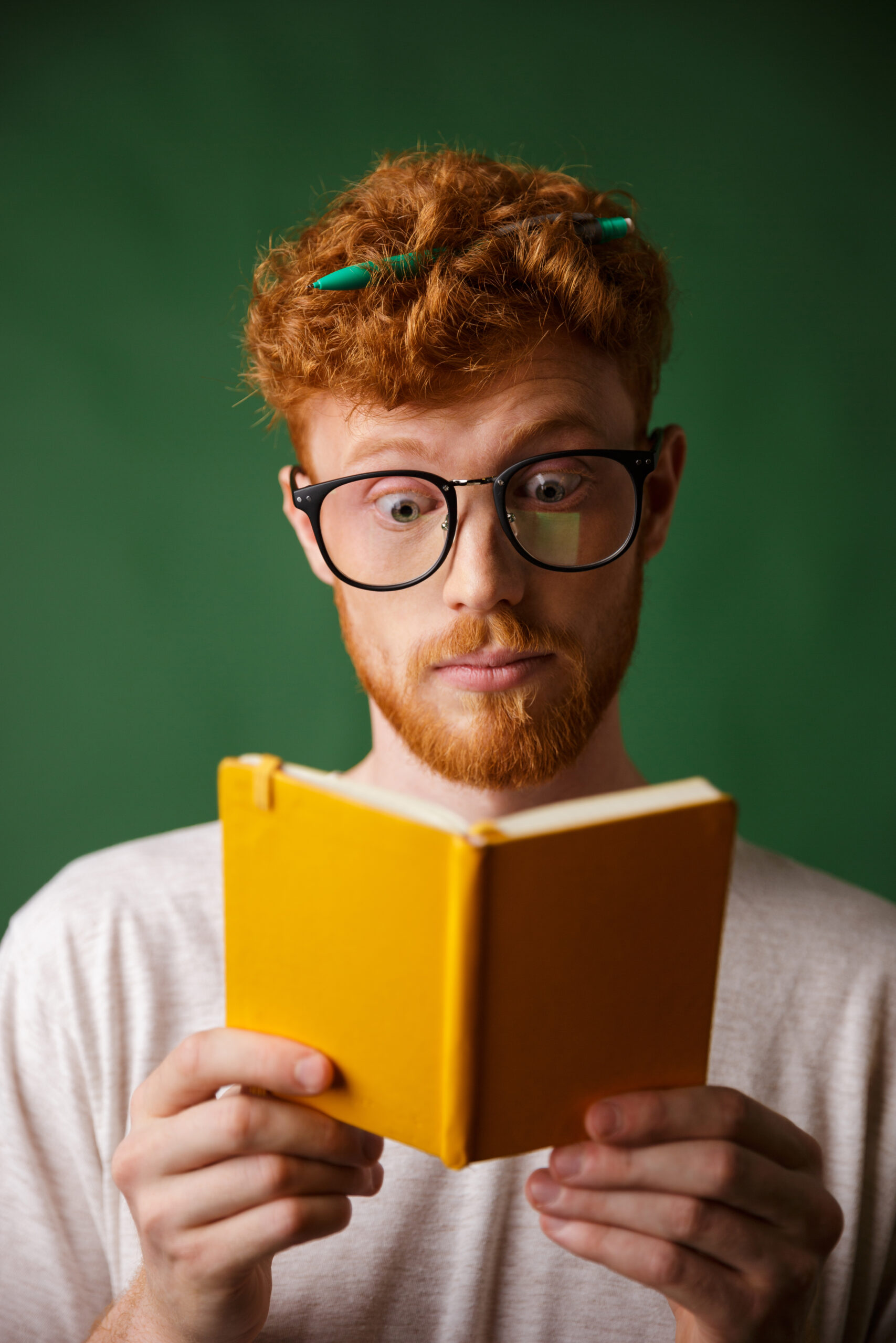 Amazed Young Red Bearded Student Glasses Reading Notebook With Pen His Hair Scaled